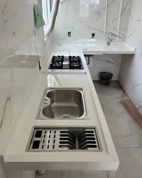 Bancada branca restaurada com cuba inox e furo de cooktop